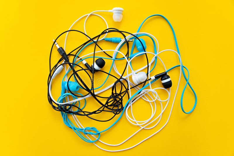 Gruppo di diversi auricolari isolati su fondo giallo. concettuale del colore. minimalismo concettuale. minima. minimo fotografia stock libera da diritti