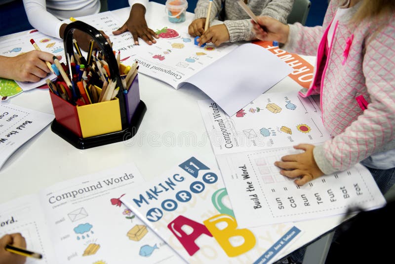 Gruppo di diversi studenti che colorano libro di esercizi nella classe immagini stock libere da diritti Gruppo di diversi studenti che colorano libro di esercizi nella classe immagini stock libere da diritti