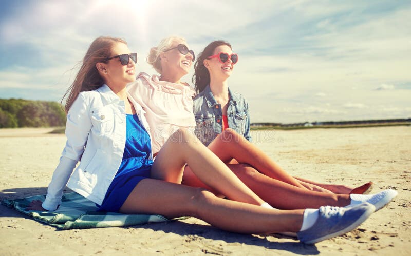 Gruppo di donne sorridenti in occhiali da sole sulla spiaggia
