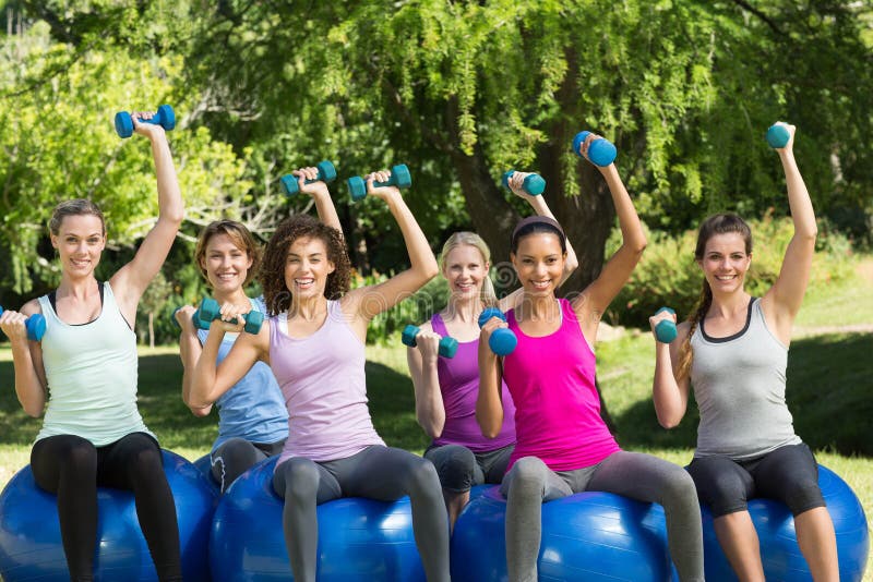 Gruppo di forma fisica facendo uso delle palle di esercizio in parco immagine stock libera da diritti Gruppo di forma fisica facendo uso delle palle di esercizio in parco immagine stock libera da diritti