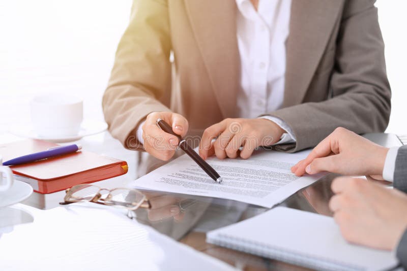 Gruppo di gente di affari o di avvocati che discute i documenti che si siedono alla tavola, primo piano del contratto immagini stock Gruppo di gente di affari o di avvocati che discute i documenti che si siedono alla tavola, primo piano del contratto immagini stock