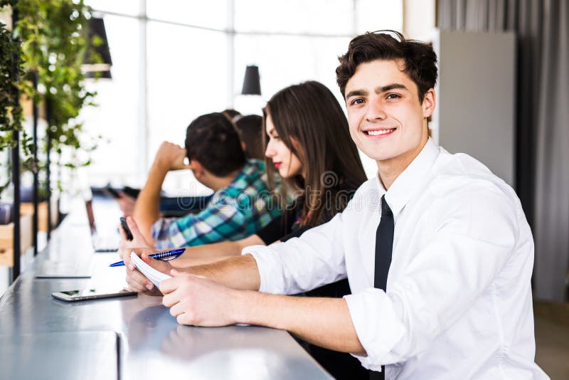Gruppo di gente di affari che per mezzo dei dispositivi di Digital Team People che lavora alla loro tavola in ufficio moderno fotografia stock libera da diritti Gruppo di gente di affari che per mezzo dei dispositivi di Digital Team People che lavora alla loro tavola in ufficio moderno fotografia stock libera da diritti