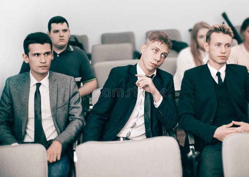 Gruppo di giovani quadri che tengono una riunione del lavoro in un auditorium fotografie stock Gruppo di giovani quadri che tengono una riunione del lavoro in un auditorium fotografie stock