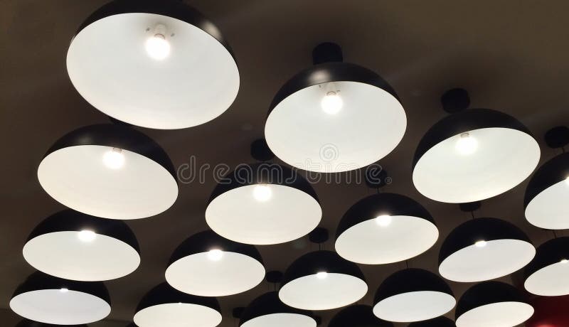 Gruppo di lampade illuminate metallo nero moderno che appendono sul soffitto fotografia stock libera da diritti Gruppo di lampade illuminate metallo nero moderno che appendono sul soffitto fotografia stock libera da diritti