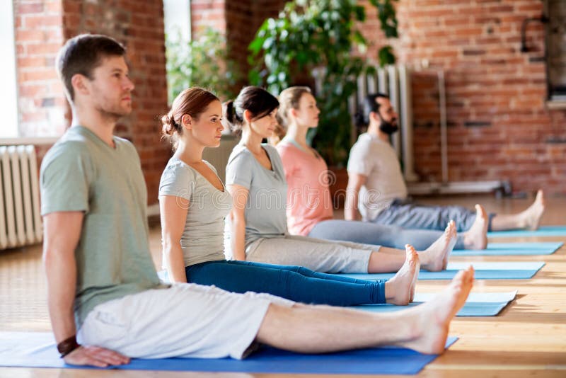 Gruppo di persone che fanno posa del personale di yoga allo studio fotografie stock libere da diritti Gruppo di persone che fanno posa del personale di yoga allo studio fotografie stock libere da diritti