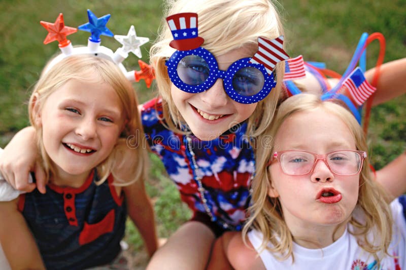 Gruppo di ragazzi felici in costumi festivi che guardano la parata il 4 luglio negli usa immagine stock
