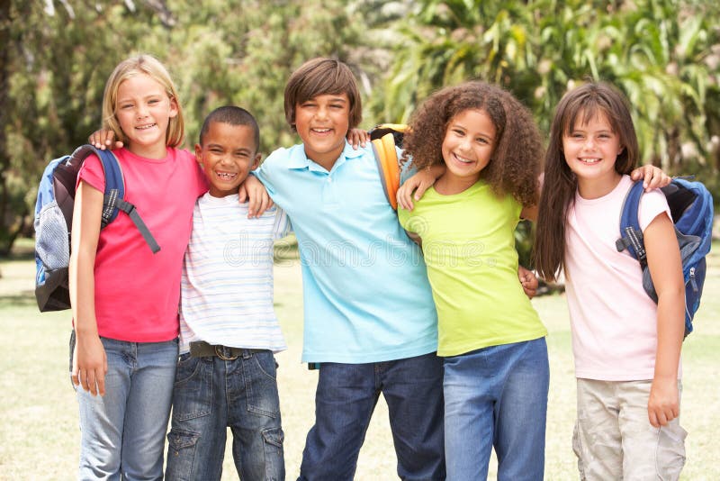 Group Of Schoolchildren Standing In Park Smiling At Camera. Group Of Schoolchildren Standing In Park Smiling At Camera