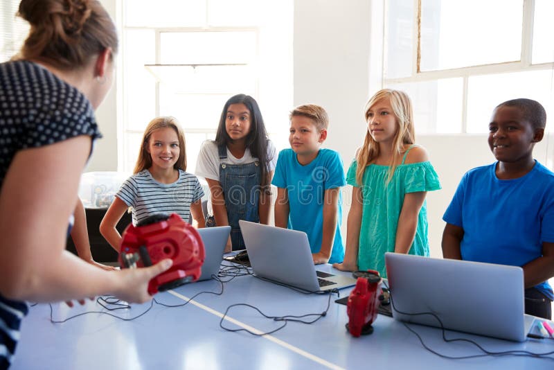 Gruppo di studenti dentro dopo la classe di codifica del computer della scuola che impara al veicolo del robot di programma immagini stock Gruppo di studenti dentro dopo la classe di codifica del computer della scuola che impara al veicolo del robot di programma immagini stock