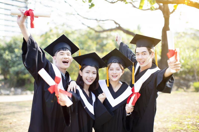 Gruppo di studenti felici che celebrano graduazione fotografia stock Gruppo di studenti felici che celebrano graduazione fotografia stock