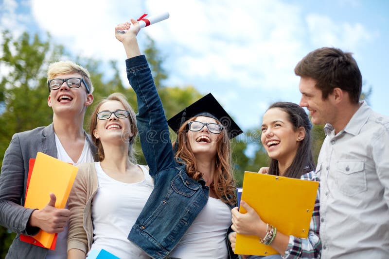 Gruppo di studenti sorridenti con il diploma e le cartelle fotografia stock Gruppo di studenti sorridenti con il diploma e le cartelle fotografia stock