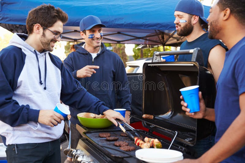 Gruppo di Tailgating maschio dei fan di sport nel parcheggio dello stadio fotografia stock Gruppo di Tailgating maschio dei fan di sport nel parcheggio dello stadio fotografia stock