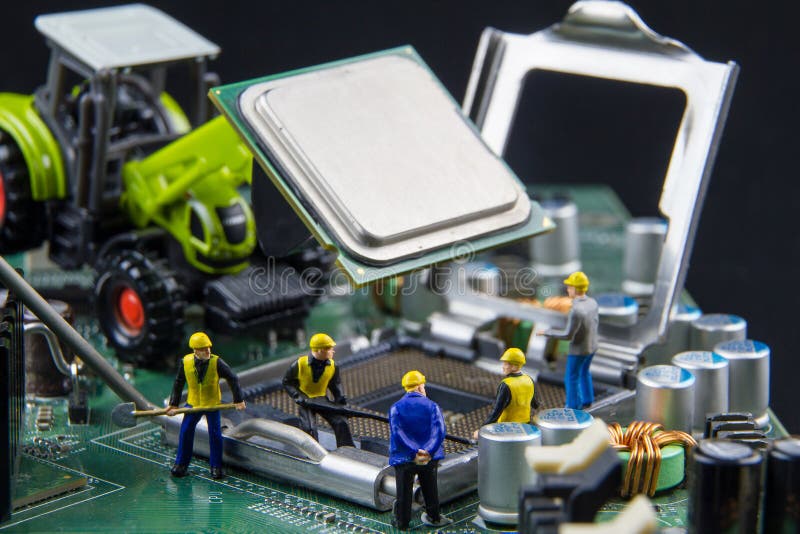 Gruppo minuscolo dei giocattoli degli ingegneri che riparano compu del bordo di madre del circuito immagine stock Gruppo minuscolo dei giocattoli degli ingegneri che riparano compu del bordo di madre del circuito immagine stock