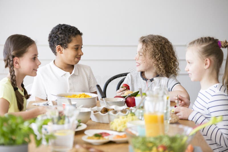 Gruppo multiculturale sorridente di bambini che mangiano alimento immagini stock libere da diritti Gruppo multiculturale sorridente di bambini che mangiano alimento immagini stock libere da diritti