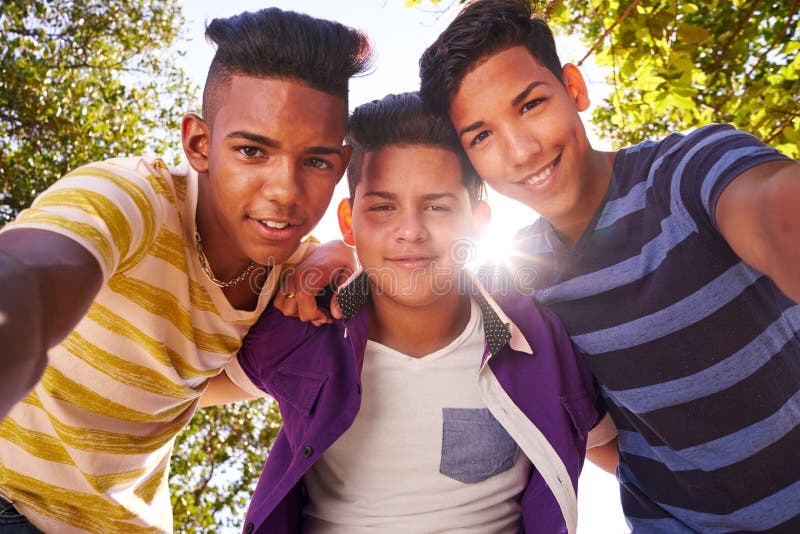 Gruppo multietnico di adolescenti che abbracciano che sorride alla macchina fotografica immagini stock libere da diritti