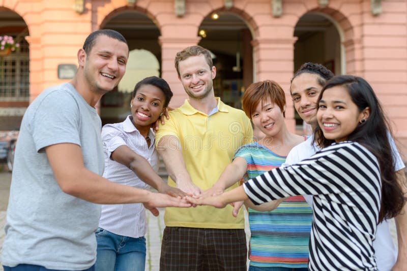 Gruppo multirazziale sorridente felice di giovani amici fotografia stock Gruppo multirazziale sorridente felice di giovani amici fotografia stock