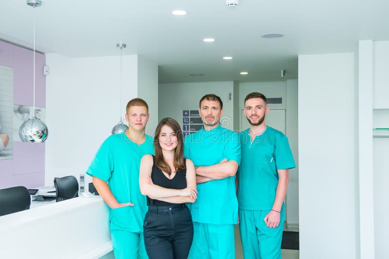 Gruppo sorridente del ritratto in uniforme che fornisce trattamento di sanit? nel centro medico moderno Clinica, professione, la immagini stock Gruppo sorridente del ritratto in uniforme che fornisce trattamento di sanit? nel centro medico moderno Clinica, professione, la immagini stock