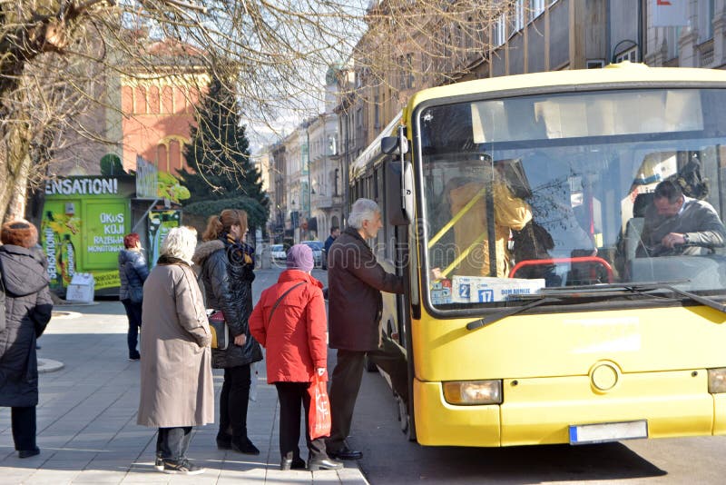 Grupy ludzi czekanie w kolejce wchodzić do lokalnego miasto autobus na autobusowym zatrzymuje stację obrazy stock Grupy ludzi czekanie w kolejce wchodzić do lokalnego miasto autobus na autobusowym zatrzymuje stację obrazy stock
