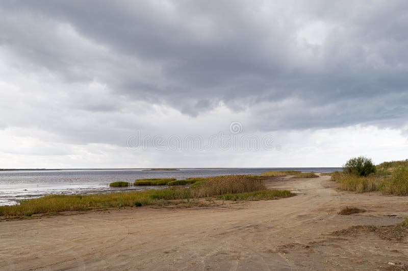 Grusväg längs havskostnaden, stormmoln royaltyfri foto Grusväg längs havskostnaden, stormmoln royaltyfri foto