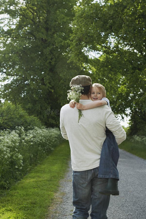 Gränd för faderCarrying Daughter On land arkivbild