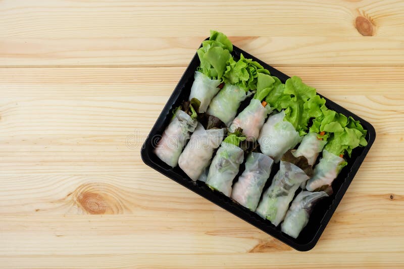 Grön ek för rullsallad och nya grönsaker för röd ek i en svart plast- ask på ett trägolv Top beskådar royaltyfri foto Grön ek för rullsallad och nya grönsaker för röd ek i en svart plast- ask på ett trägolv Top beskådar royaltyfri foto