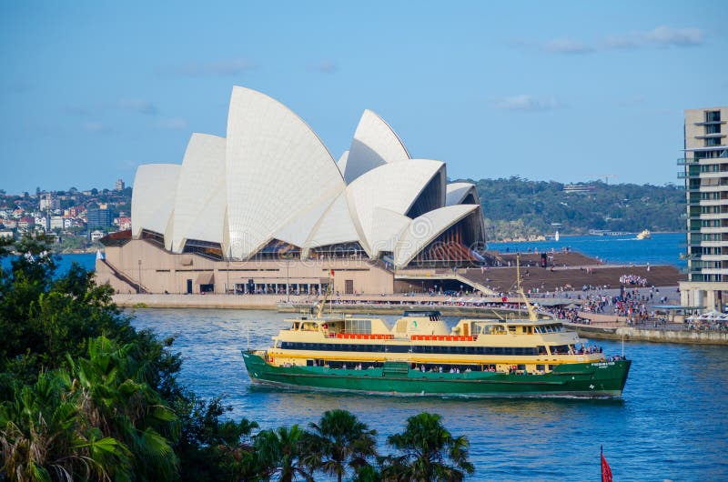 Grön färja i den Sydney hamnen med operahuset på bakgrunden arkivbild Grön färja i den Sydney hamnen med operahuset på bakgrunden arkivbild