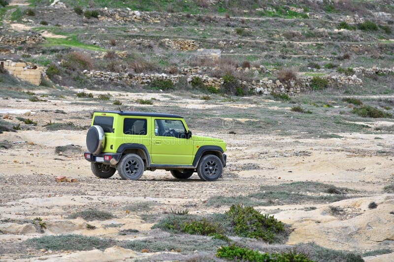 Grön liten suv 4x4 parkerad på sjön arkivbilder