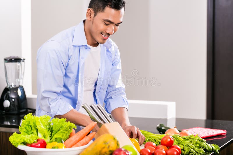 Grönsaker och sallad för asiatisk man bitande arkivfoto