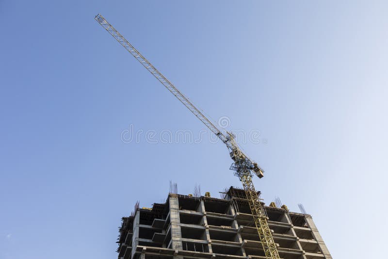 Grúa de construcción con el edificio alto bajo construcción foto de archivo libre de regalías Grúa de construcción con el edificio alto bajo construcción foto de archivo libre de regalías