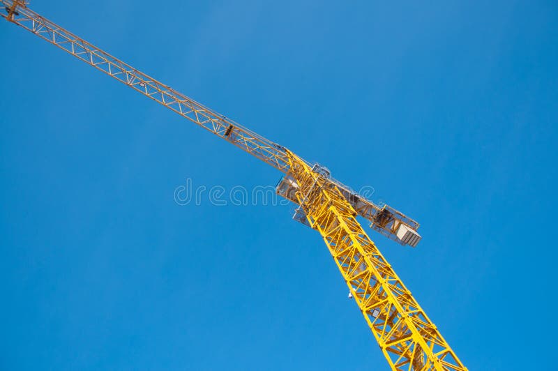 Grúa de construcción contra el cielo azul con las nubes imagen de archivo Grúa de construcción contra el cielo azul con las nubes imagen de archivo