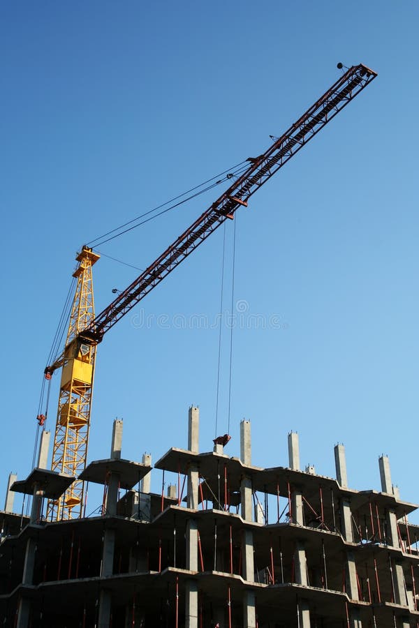 Grúa y edificio nuevo imagenes de archivo