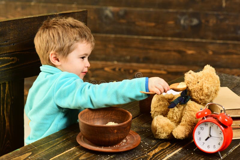 Grüne Borduhrplatte auf Weiß Kleines Kind und Teddybär haben Mahlzeit zusammen Jungenzufuhr-Spielzeugfreund mit gesunder Mahlzeit lizenzfreie stockfotos Grüne Borduhrplatte auf Weiß Kleines Kind und Teddybär haben Mahlzeit zusammen Jungenzufuhr-Spielzeugfreund mit gesunder Mahlzeit lizenzfreie stockfotos