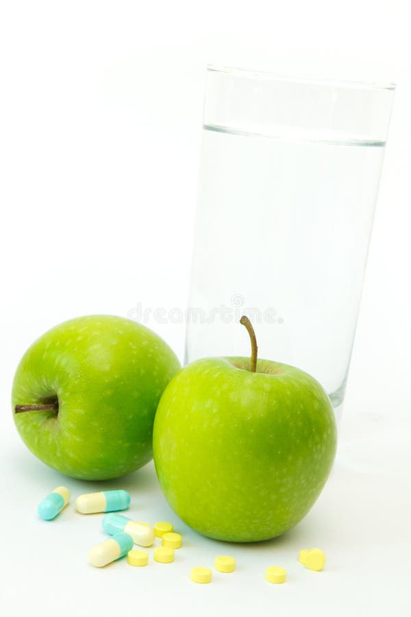 Grüner Apfel mit dem Abnehmen der Pillen stockfotografie Grüner Apfel mit dem Abnehmen der Pillen stockfotografie