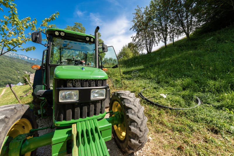 Grüner Traktor auf den italienischen Alpen lizenzfreie stockfotografie Grüner Traktor auf den italienischen Alpen lizenzfreie stockfotografie