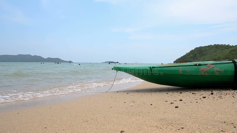 Grünes Boot auf dem Sandstrand mit Naturseeumgebendem Ton