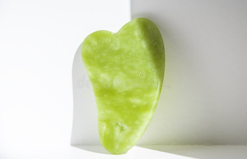 Green Gua Sha Massage Jade Roller and Face Cream in White Container on