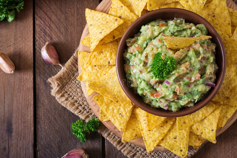 Guacamoleavokadot, limefrukt, tomaten, lök och koriander, tjänade som med nachos royaltyfri foto Guacamoleavokadot, limefrukt, tomaten, lök och koriander, tjänade som med nachos royaltyfri foto