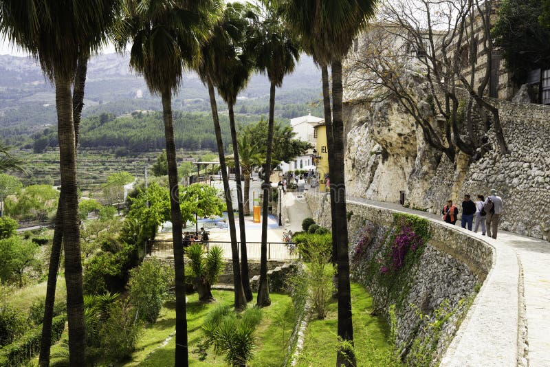 Guadalest, provincia de Alicante España 21 de abril de 2018: La pared del castillo famoso de Guadalest en un lado y las palmeras fotografía de archivo libre de regalías Guadalest, provincia de Alicante España 21 de abril de 2018: La pared del castillo famoso de Guadalest en un lado y las palmeras fotografía de archivo libre de regalías