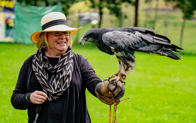 Gualaceo, Ecuador / June 1, 2018: A woman holds a bird of prey a