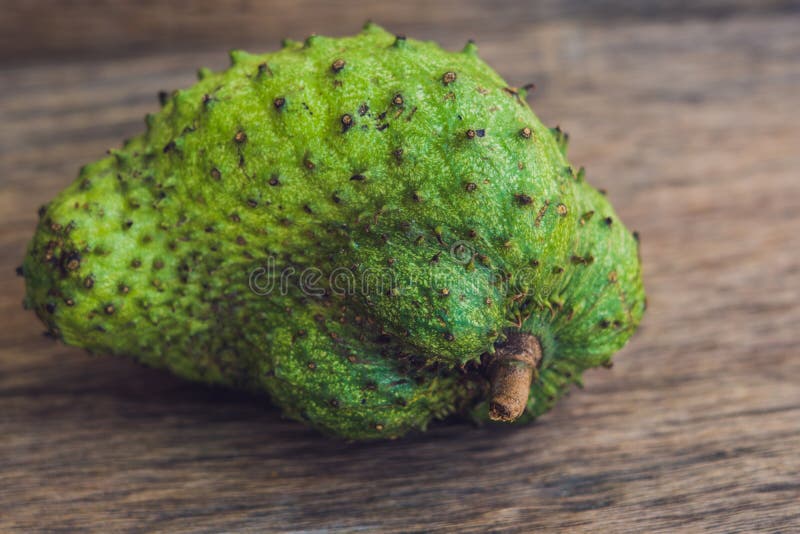 Guanabana op een oude houten achtergrond - exotisch tropisch fruit - regionale vruchten van Vietnam royalty-vrije stock afbeeldingen Guanabana op een oude houten achtergrond - exotisch tropisch fruit - regionale vruchten van Vietnam royalty-vrije stock afbeeldingen