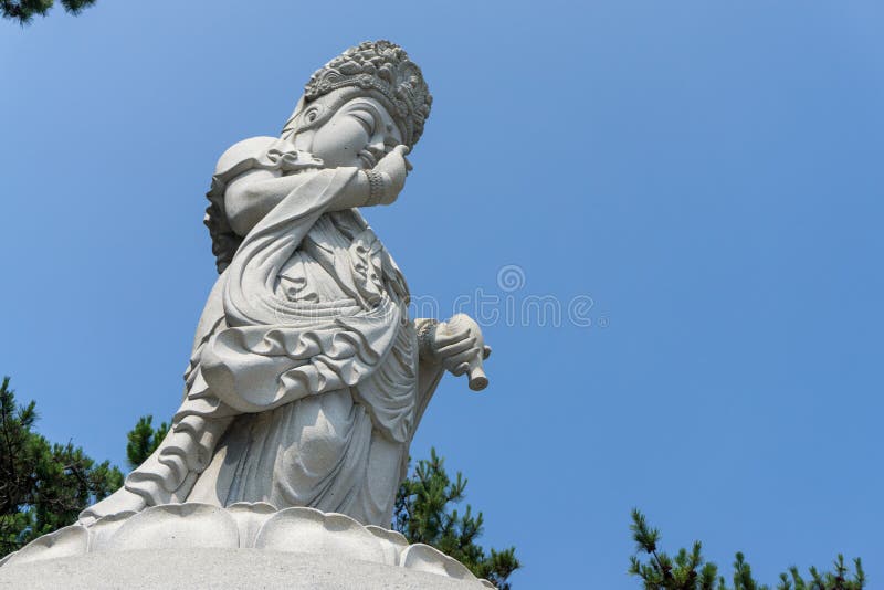 Guanyin ou Guan Yin Goddess da estátua de pedra branca da mercê no templo de Haedong Yonggungsa imagem de stock royalty free Guanyin ou Guan Yin Goddess da estátua de pedra branca da mercê no templo de Haedong Yonggungsa imagem de stock royalty free