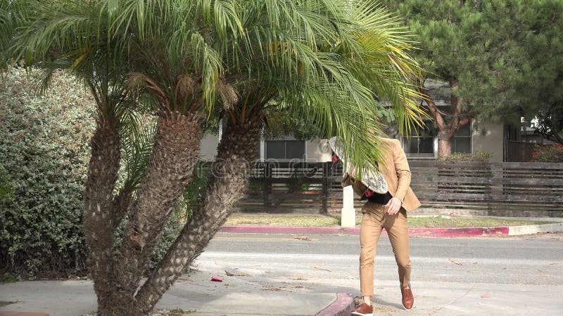 Guapo joven con traje caminando con patineta almacen de video