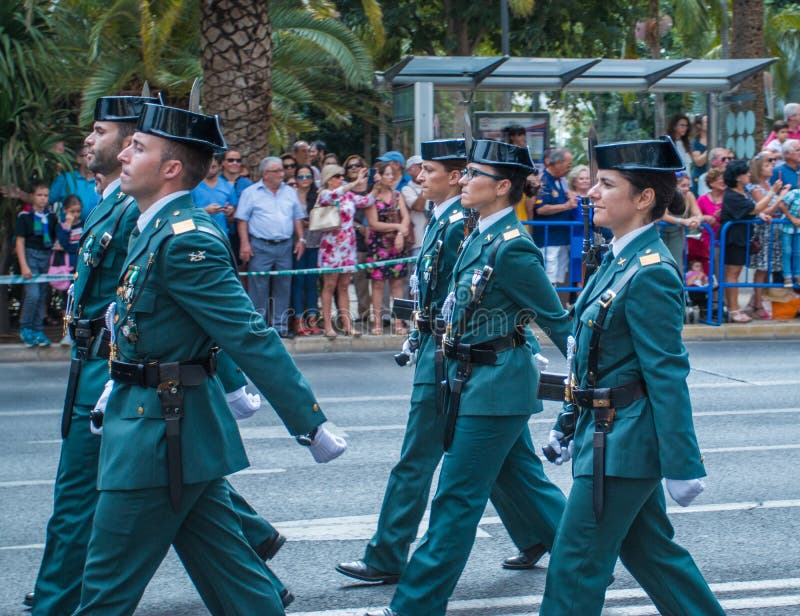 Malaga, Spain - October 04, 2015: Women and men in police uniform marching on parade down the street. Guardia Civil Parade in Malaga, Spain on October 04, 2015. Malaga, Spain - October 04, 2015: Women and men in police uniform marching on parade down the street. Guardia Civil Parade in Malaga, Spain on October 04, 2015