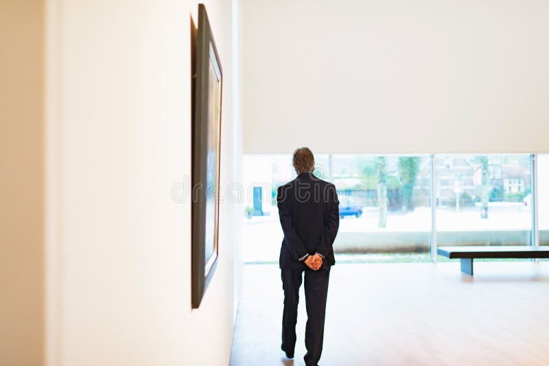 Guardian walking in white museum room.