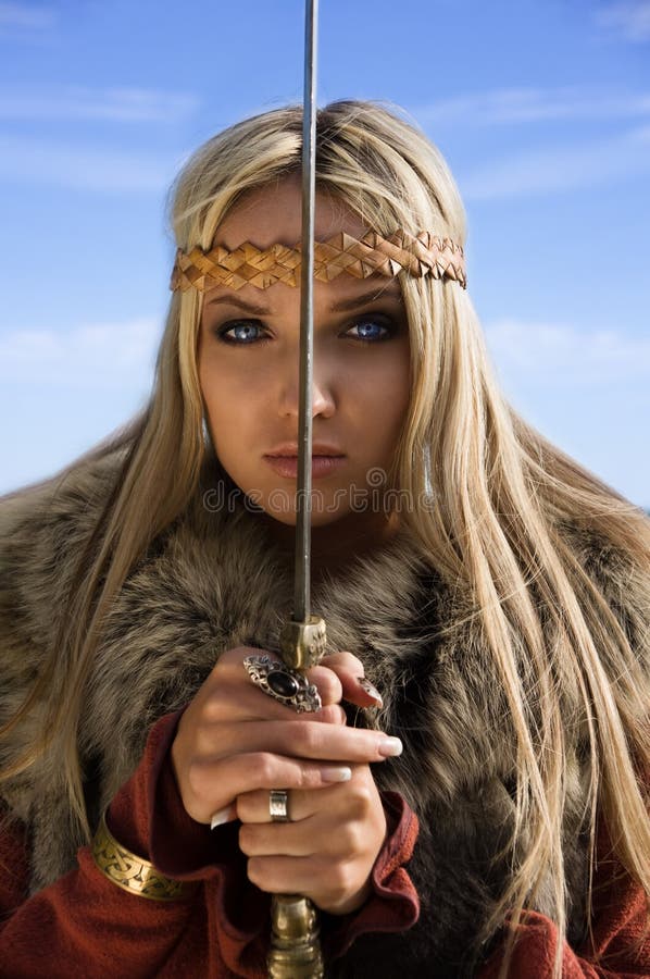 Guerrero de la muchacha de Vikingo en un fondo del cielo azul foto de archivo Guerrero de la muchacha de Vikingo en un fondo del cielo azul foto de archivo