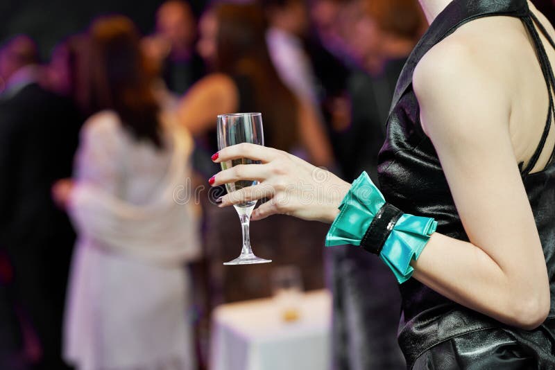 Guest hand and glass with wine at party