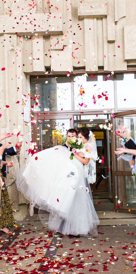 Guests Throwing Confetti Over Bride And Groom At Wedding stock image Guests Throwing Confetti Over Bride And Groom At Wedding stock image