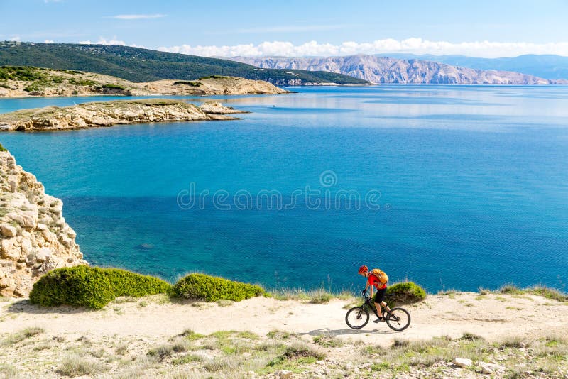 Guida del ciclista in mountain-bike sulla bici in legno di tramonto di estate fotografie stock libere da diritti Guida del ciclista in mountain-bike sulla bici in legno di tramonto di estate fotografie stock libere da diritti