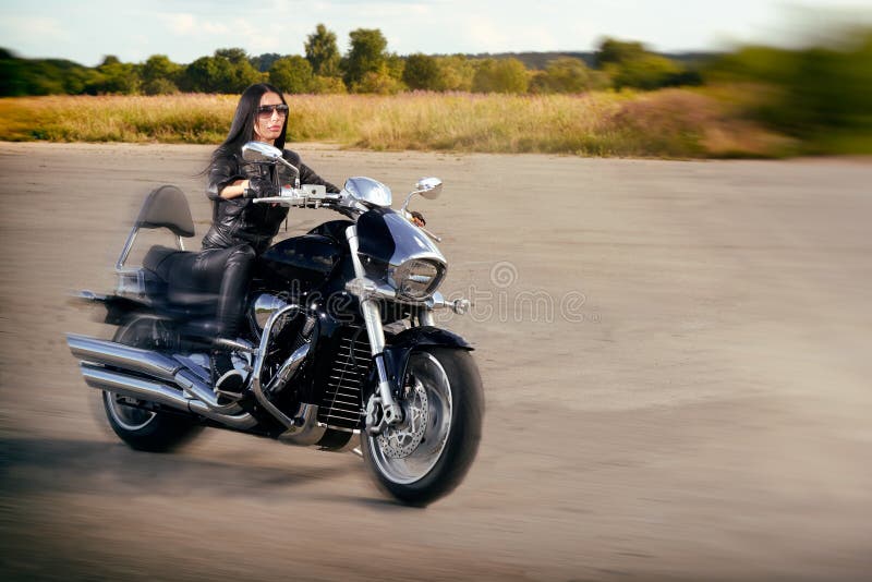 Guida della ragazza del motociclista su un motociclo immagini stock libere da diritti Guida della ragazza del motociclista su un motociclo immagini stock libere da diritti