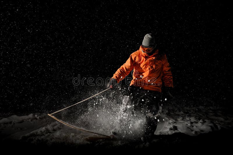 Guida maschio professionale dello snowboarder sulla neve alla notte fotografie stock Guida maschio professionale dello snowboarder sulla neve alla notte fotografie stock