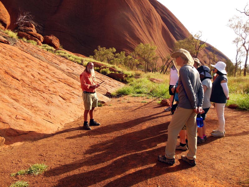 An Aboriginal guide conducts a tour for visitors to Uluru located in the center of Australia. He explains the ancient history and ancestral legends of this sacred site for the native Pitjantjatjara people. The spiritual landmark was once called Ayers Rock before it was renamed using the traditional dialect of its Aboriginal caretakers. An Aboriginal guide conducts a tour for visitors to Uluru located in the center of Australia. He explains the ancient history and ancestral legends of this sacred site for the native Pitjantjatjara people. The spiritual landmark was once called Ayers Rock before it was renamed using the traditional dialect of its Aboriginal caretakers.
